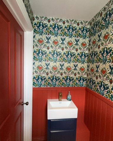 Brightly decorated bathroom with patterned wallpaper and a white sink unit.