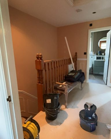 Cluttered hallway with tools, a bench, and a staircase to the left.